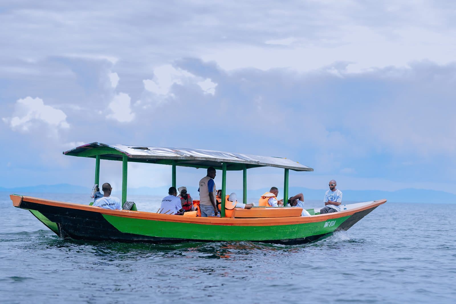 A covered passenger boat crossing open water on Lake Kivu
